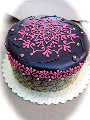 A Decorated Chocolate Cake With Pink Frosting On Top