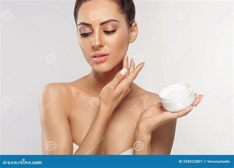 Skin Care Portrait Of Female Model Holding And Applying Cosmetic