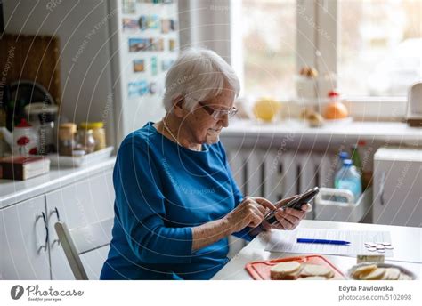 Ältere Frau benutzt Mobiltelefon zu Hause ein lizenzfreies Stock Foto