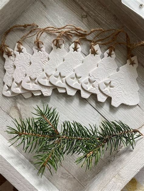 Some Ornaments Are Sitting In A Box On A Table With Pine Needles And Twine