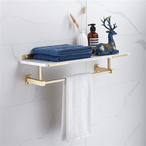 A Towel Rack With Two Towels On It Next To A Bottle And Soap Dispenser