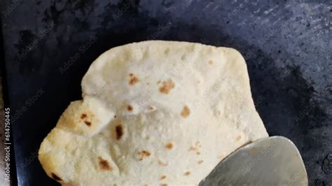 A Close Up Of An Indian Chef Skillfully Preparing Fresh Chapatis On A