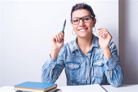 Premium Photo Latina Woman Studying At Home Seated With Pen In Hand And Books College Concept