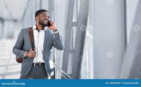 African Businessman Walking Inside Airport And Talking On Phone Stock