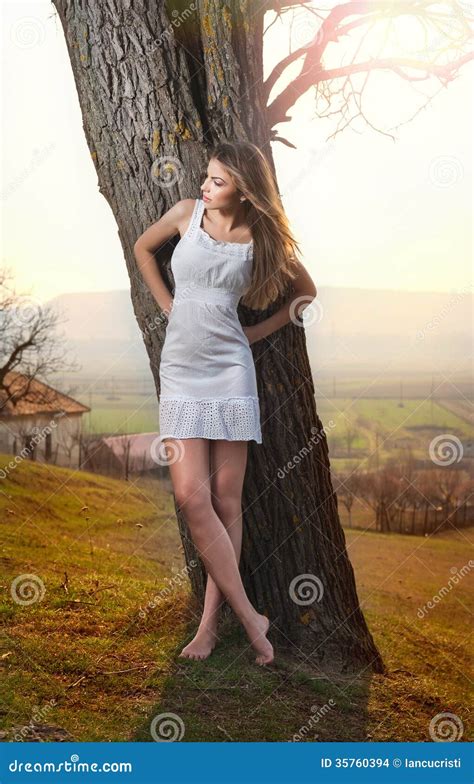 Beautiful Girl Portrait With Hat Near A Tree In The Garden Young