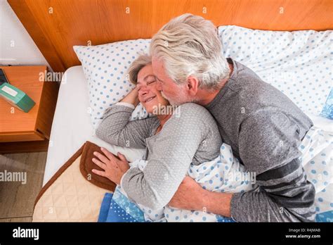 Rentner im Alter von Paar 70 Jahre alt im Bett am Morgen küssen und