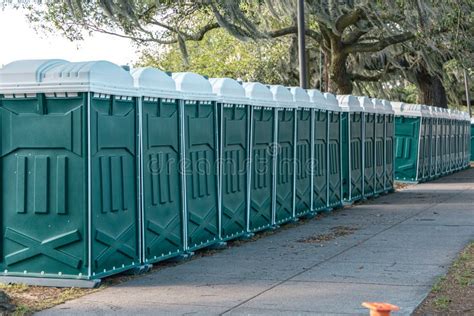 Row Of Green Porta Portable Potty Outhouses Ready For Use At A Concert