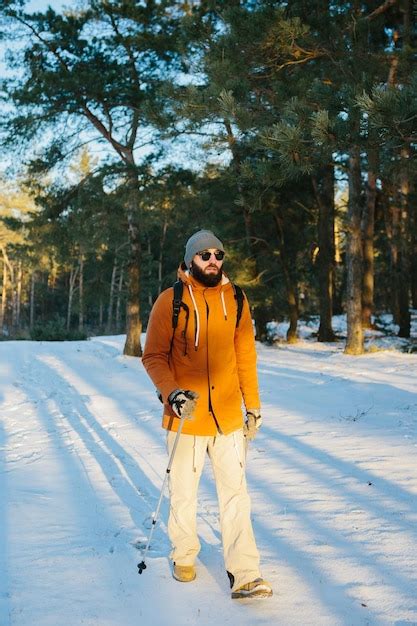 Premium Photo A Man On A Hike With A Backpack In A Snowy Winter Forest