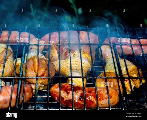 Des Cuisses De Poulet Et Des Saucisses De Viande Sur Un Filet Barbecue