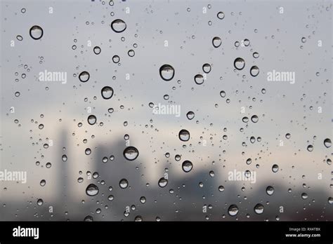 Las Gotas De Lluvia Sobre El Cristal De La Ventana Y La Silueta De La