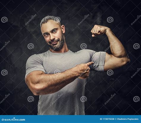 Strong Adult Caucasian Muscular Bodybuilder Coach Showing His Muscles