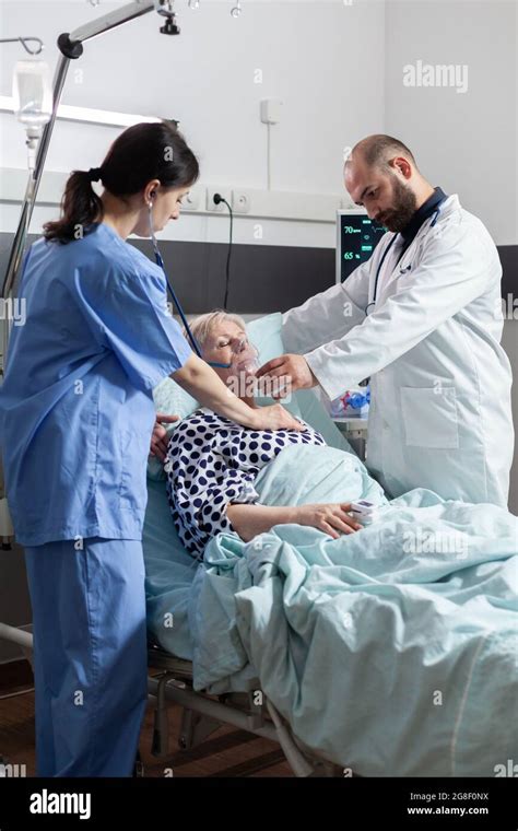 Doctor Holding Oxygen Mask For Senior Woman Patient Helping Her Breath