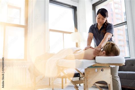 Chinese Woman Massage Therapist Giving A Treatment To An Attract Stock