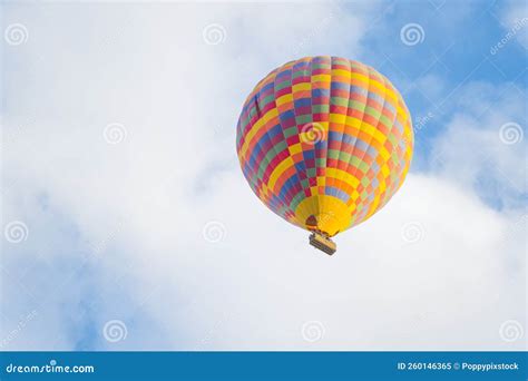 Patterned Colourful Hot Air Balloon Flying On The Cloudy Blue Sky