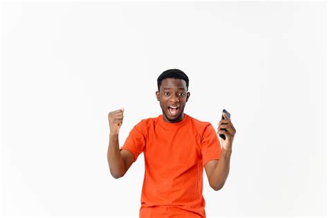 Premium Photo Emotional Man In An Orange Tshirt With A Phone In His