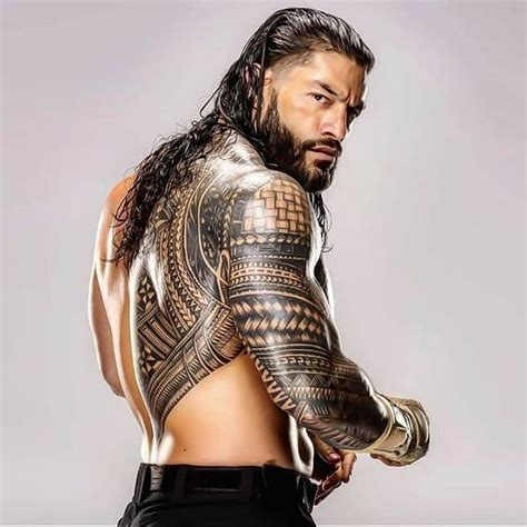 a man with long hair and tattoos on his arm