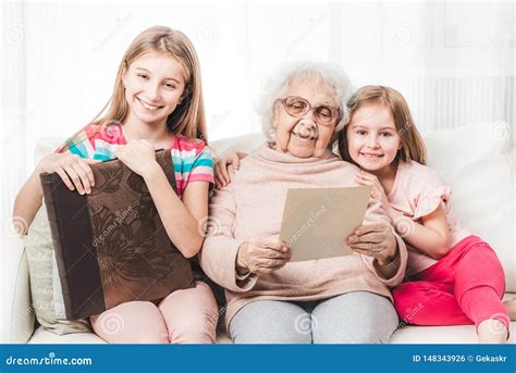 Smiling Grandmother With Granddaughters Looking Stock Photo Image Of