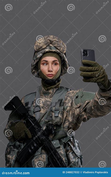 Female Special Forces Soldier With Cellphone Against Grey Background