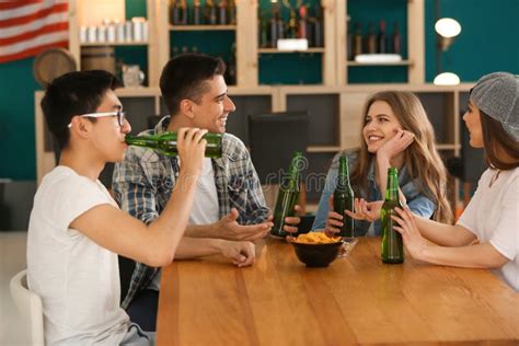 Grupo De Amigos Alegres Que Beben La Cerveza En Barra Imagen De Archivo