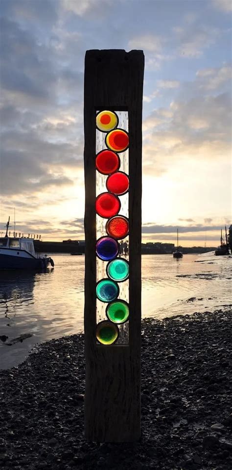 Found Wood With Colorful Stained Glass Embedded Within Cast Prismatic Shadows On The Beach