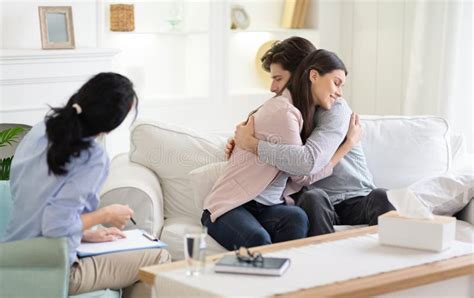 Married Couple Embracing At Therapist Office Having Marital Therapy