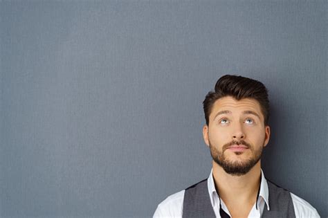 Thoughtful Man Standing Against Dark Background Stock Photo Download