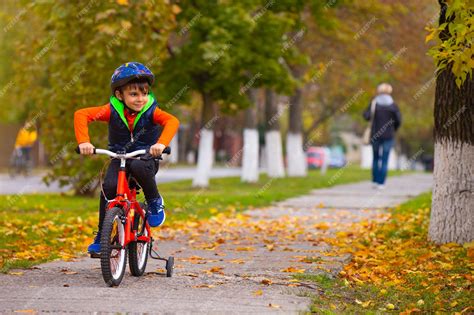 Niño En Bicicleta En El Parque Niño Pequeño Con Casco Y Bicicleta En