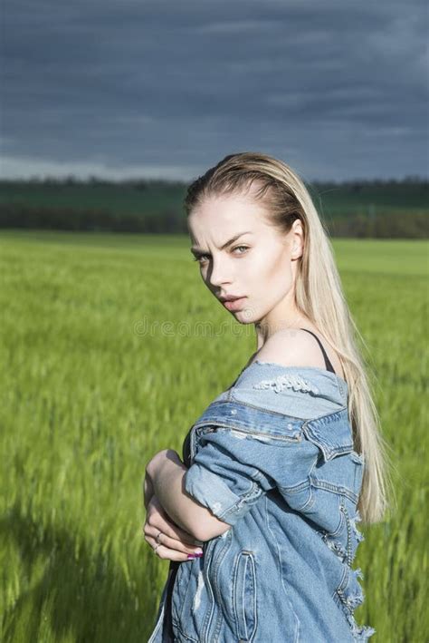 Beautiful Blonde Girl Is Standing In A Field Against A Background Of Clouds Stock Image Image