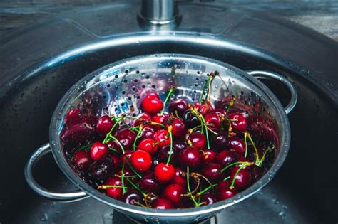 Cerezas Rojas Maduras Lavadas En Un Colador Foto Premium