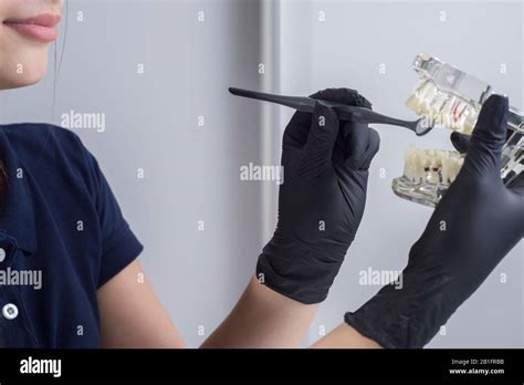 Close Up Of A Dentist Doctor Smiling Wearing Gloves Holding In His