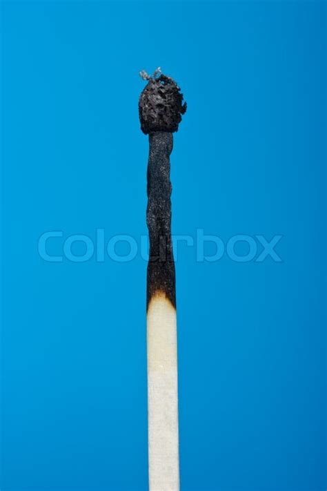 Burnt match stick isolated on blue | Stock image | Colourbox