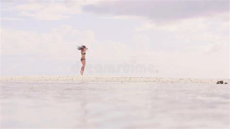 Jeune Femme Dans Le Bikini De Plage Sautant Et Dansant Sur Le Sable