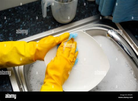 A Woman Washing Pots Wearing Yellow Rubber Gloves Stock Photo Alamy