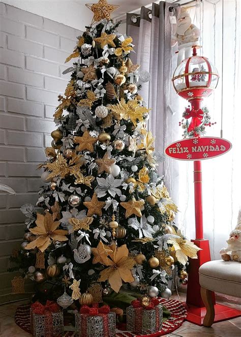 A Decorated Christmas Tree With Gold And Silver Decorations In Front Of