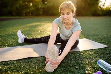 Mature Woman Practicing Yoga Outdoor Exercise Or Doing Fitness Stock