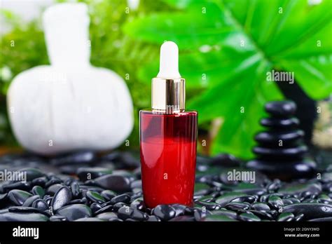 Thai Spa Massage Setting With Red Serum Oil Bottle Dropper Mock Up Or Essential Oil On Black