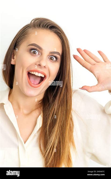 Portrait Of Young Caucasian Woman Wearing White Shirt Raises Hands And