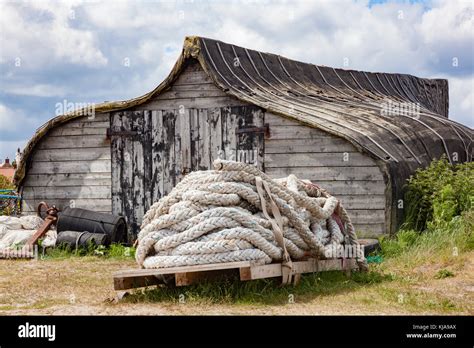 Traditional Upturned Boat Hulls Used As Storage Sheds For Boat Owner On