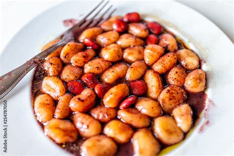 Closeup Of Fresh Red Wine Sauce Potato Gluten Free Wheat Gnocchi On White Plate With Lupine