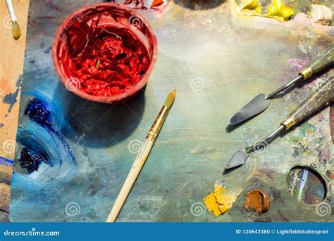 Painting Brushes Palette And Red Poster Paint On Wooden Table Stock