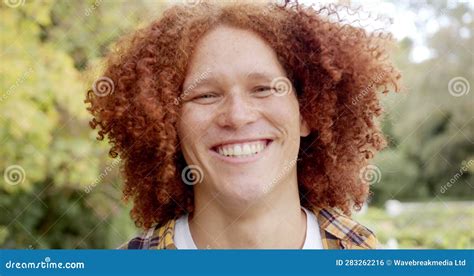 Portrait Of Happy Biracial Man With Curly Red Hair And Freckles Smiling