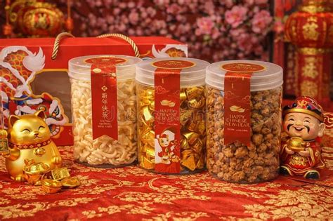 Three Jars Of Traditional Chinese New Year Snacks With Gold Decorations