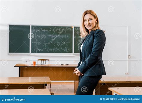 Beautiful Female Teacher In Formal Wear Smiling And Looking At Camera