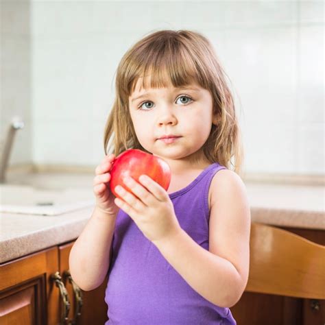 Retrato de una niña con manzana roja fresca | Foto Gratis