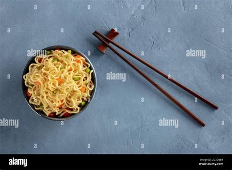 Instant Noodles Bowl With Carrot And Scallions With Chopsticks Shot