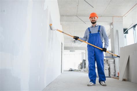 Premium Photo Painter In Uniform Paints The Wall