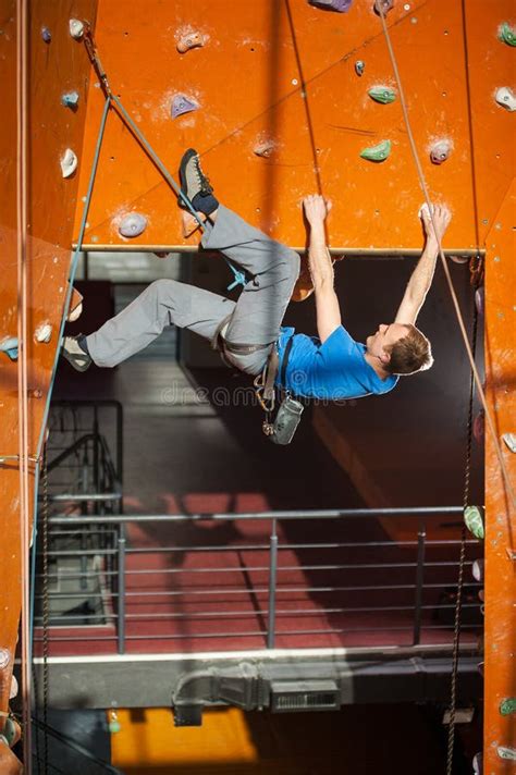 Male Rock Climber Practicing Climbing On Rock Wall Indoors Stock Photo