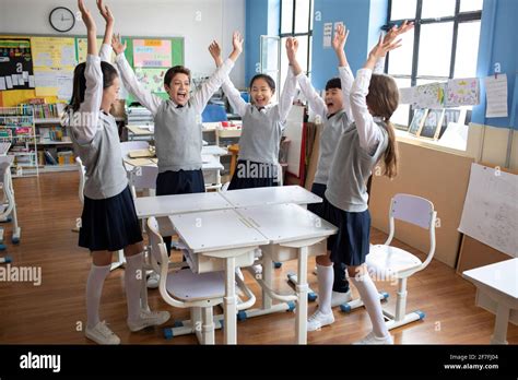 Classmates cheering in classroom Stock Photo - Alamy