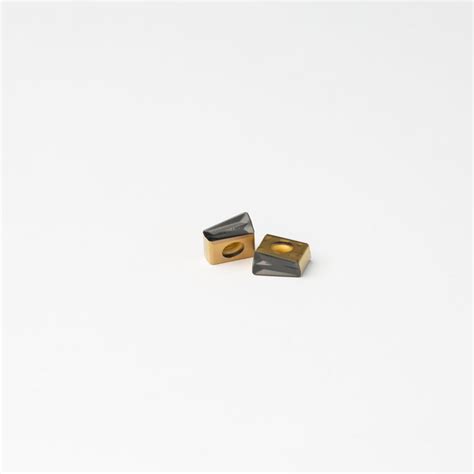 Two Gold And Black Rings Sitting On Top Of A White Surface With One