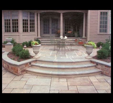 an outdoor patio with steps leading up to the front door and dining ...